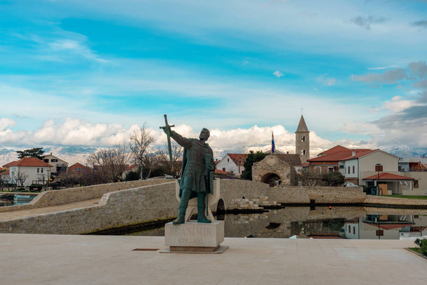 Entrada a la histórica ciudad de Nin con estatua del duque croata Branimir. - Foto, imagen