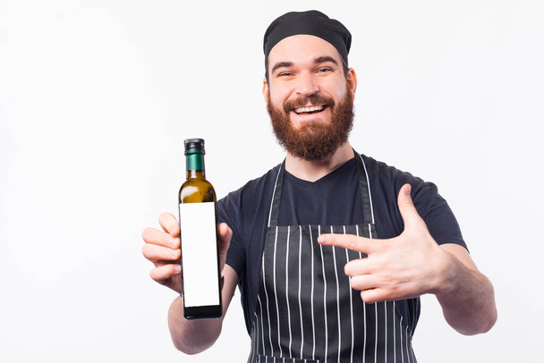 Smiling Barista man pointing at best olive oil bottle - Foto, immagini