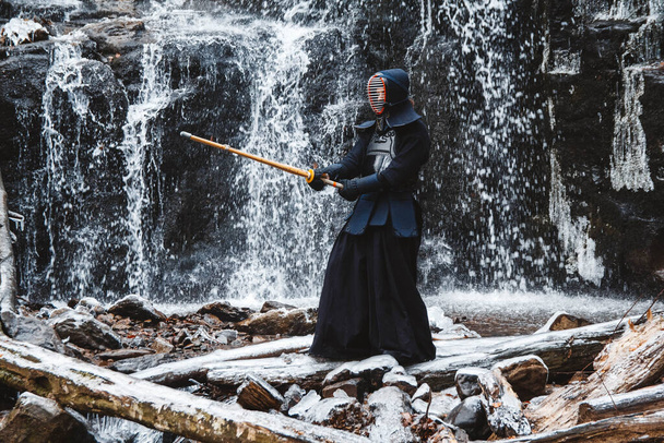 滝を背に竹刀で剣道をする男。テキストまたは広告の場所. - 写真・画像