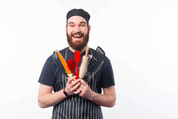 Foto de homem Chef barbudo espantado segurando utensílios na mão - Foto, Imagem