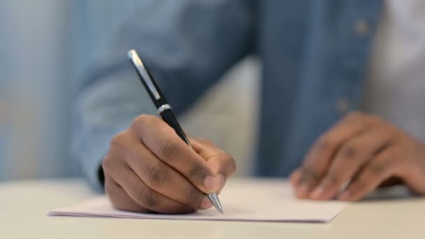 Kezek afrikai férfi írásban papíron tollal, közelkép - Felvétel, videó