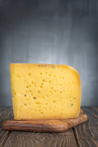 Egy darab ammergauer sör sajt egy könnyű fa asztalon. - Fotó, kép
