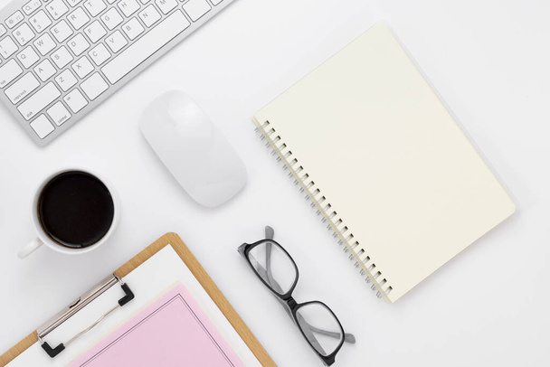Minimal Office desk table top view with office supply and coffee cup on a white table with copy space, White color workplace composition, flat lay - Foto, Imagem