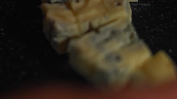 Dänischer Blauschimmelkäse, der auf einem hölzernen Tablett mit Honig, griechischen Nüssen, Cheddar-Käsewürfeln, Mozzarella und Schweineschinken-Scheiben als schmackhafte und attraktive Vorspeise arrangiert wird. 4K-Video. Kunstschuss - Filmmaterial, Video