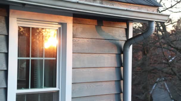 západ slunce se odráží na oknech měšťanského domu v malé klidné vesnici. Sluníčko v zimě. 4k - Záběry, video