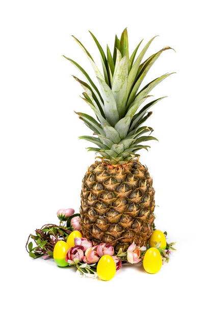 Easter composition of pineapple, flower wreath and colored eggs on white - Fotoğraf, Görsel