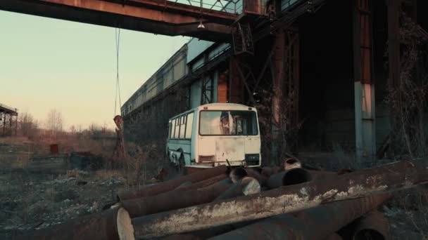 Velho retro enferrujado quebrado abandonado ônibus no escuro industrial pós paisagem apocalíptica - Filmagem, Vídeo