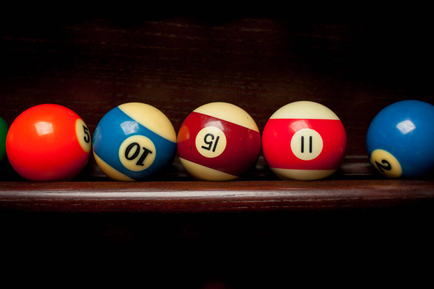 Balls for pool billiards on the shelf , billiard balls for American billiards , balls for Russian billiards , colored or white balls for billiards on a wooden background. Close-up photo. Soft focus. - Photo, Image