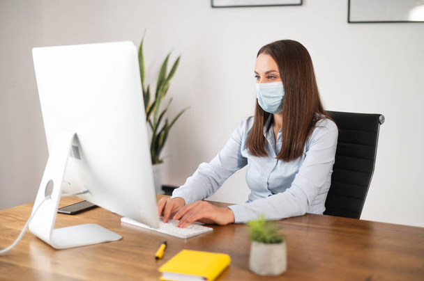 A woman in medical mask in the office - Photo, Image
