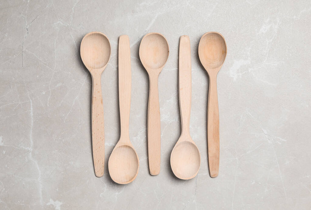 Wooden spoons on grey table, flat lay. Cooking utensils - Photo, Image