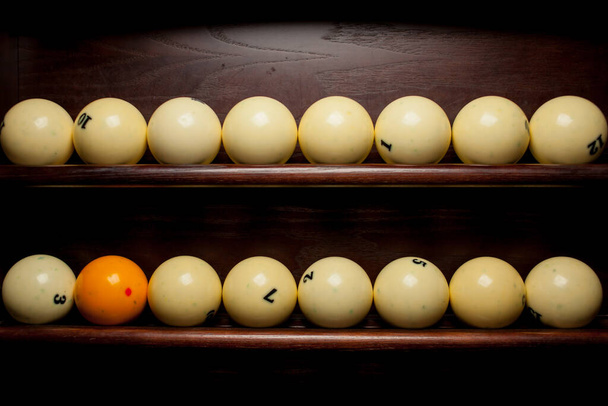Balls for pool billiards on the shelf , billiard balls for American billiards , balls for Russian billiards , colored or white balls for billiards on a wooden background. Close-up photo. Soft focus. - Foto, afbeelding
