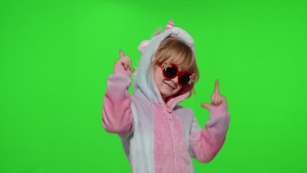 Kleines Mädchen lächelt, tanzt, macht Pistolengeste mit Händen im Einhorn-Pyjama auf Chroma-Schlüssel - Filmmaterial, Video