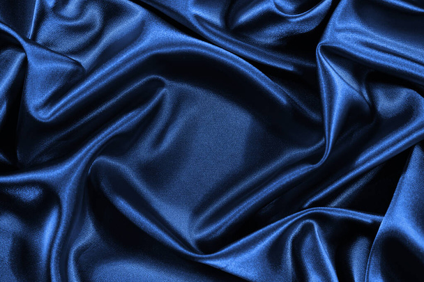 Fond en satin de soie bleu. Tissu brillant avec plis ondulés. Beau fond de tissu avec espace vide pour votre produit et design. - Photo, image