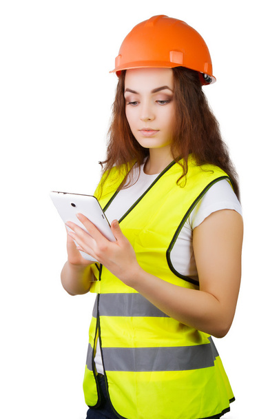 Дівчина будівельник в шоломі і жилет з електронним планшетом в руках. Вона ізольована. білий фон
. - Фото, зображення