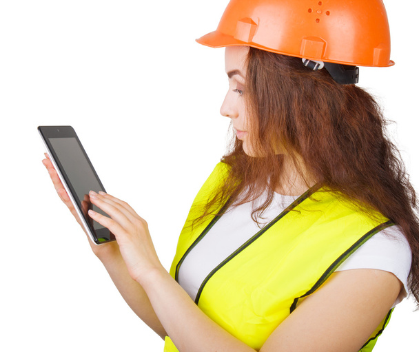 The girl the builder in a helmet and a vest with an electronic tablet in hands. It is isolated. white background. - Foto, Bild
