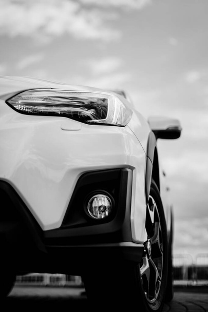 バンパー、白いスポーツカーのフロント。車は道路上にあります。デザインのための要素新しいきれいな白いスポーツカーのヘッドライト。白黒の画像です - 写真・画像