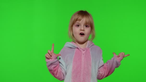 Kindermädchen im Einhorn-Pyjama macht alberne lustige Gesichter, albert herum, zeigt Zunge auf Chroma-Schlüssel - Filmmaterial, Video