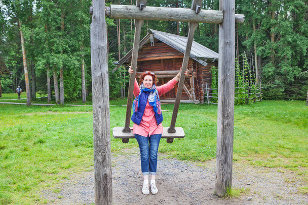 Eine Frau reitet auf einer alten Holzschaukel. "Kleine Korels". Gebiet Archangelsk. Russland. - Foto, Bild