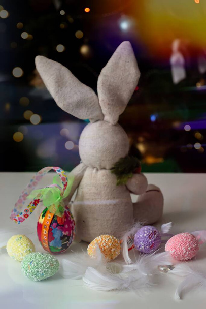 Wielkanocna dekoracja z króliczkiem zabawką, malowane jajka na czarno-białym tle z bokeh - Zdjęcie, obraz