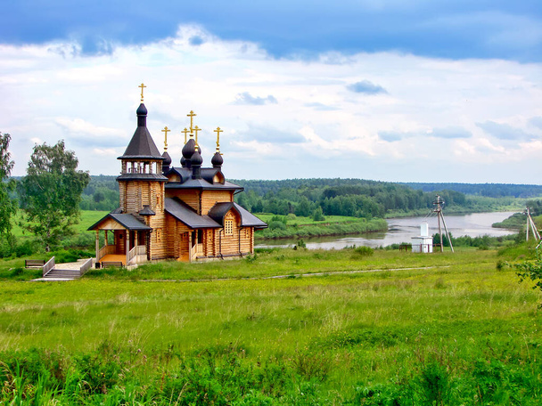 Holy Trinity Cathedral omgeven door weelderig groen en rivier, Verkhoturye, Rusland - Foto, afbeelding