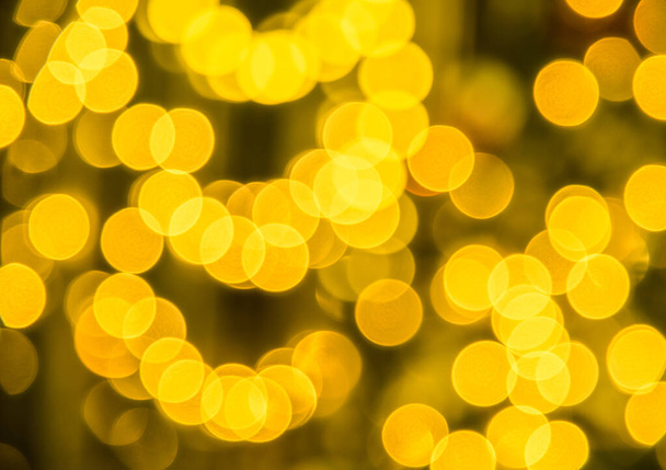 Krásné zlaté bokeh efekt jasná světla na rozmazaném tmavém pozadí, zblízka - Fotografie, Obrázek