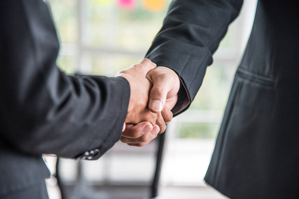 A Businessman and a business woman are shaking hands in the office for business agreement. Close- up hands. - Photo, Image
