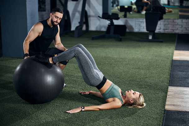 Sportsperson doing a hamstring curl on a fitness ball - Foto, immagini