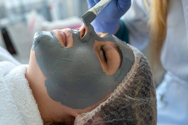 αισθητικός εφαρμογή προσώπου μάσκα για γυναίκα πελάτη σε spa σαλόνι. Υγεία - Φωτογραφία, εικόνα