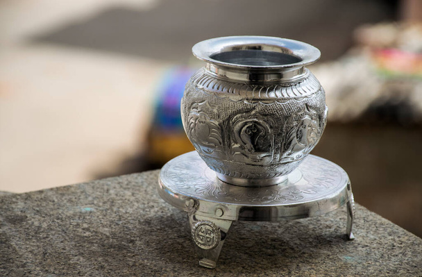 Beau pot en argent sculpté ou kalash et stand utilisé dans les rituels hindous, sur fond flou. - Photo, image