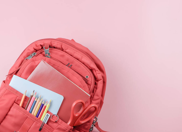 Top view of red school backpack with school supplies  on pink background with copy space. Back to school concept. - Foto, Bild