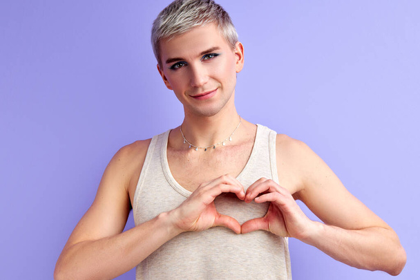 handsome fashion model with make-up make heart shape from hands - Foto, immagini