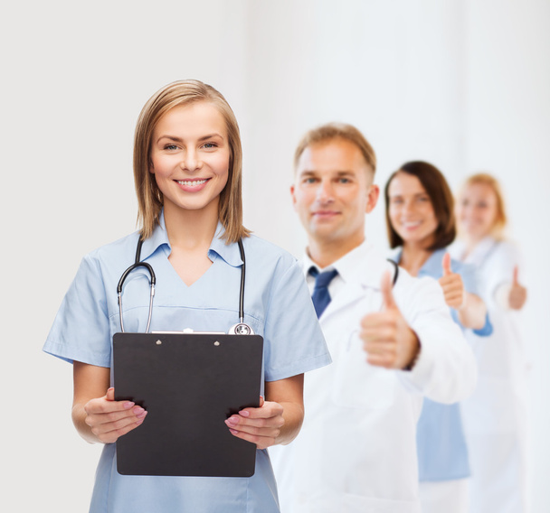 Smiling female doctor or nurse with clipboard - Foto, imagen