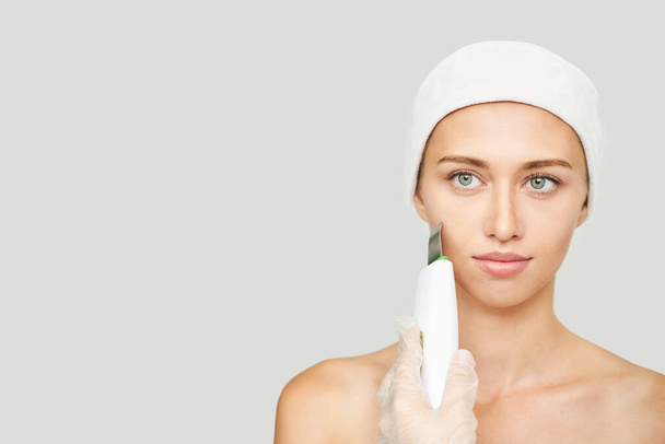 Ultrasonic skin equipment. Woman face cosmetology treatment. Female clinic - Foto, immagini