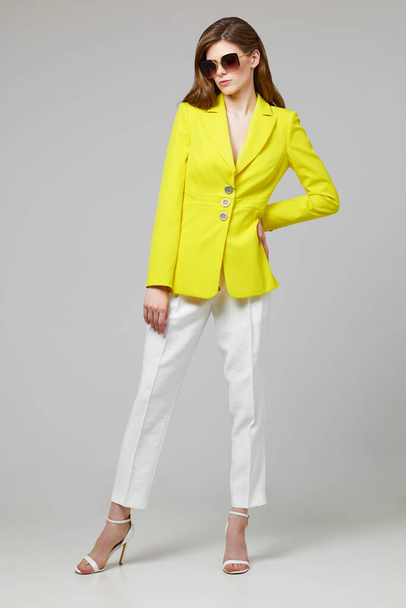 Fashion portrait of young elegant woman in trendy yellow jacket. Studio shot. - Φωτογραφία, εικόνα