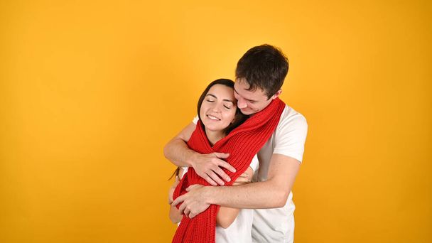 joven pareja feliz se abrazan, sobre un fondo amarillo. Foto de alta calidad - Foto, imagen