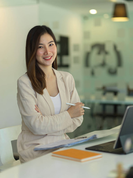 Portrait of businesswoman smiling to camera while working in office room  - Photo, image
