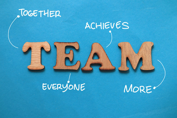 TEAM together everyone achieves more, text words typography written on paper against blue background, life and business motivational inspirational concept - Фото, изображение