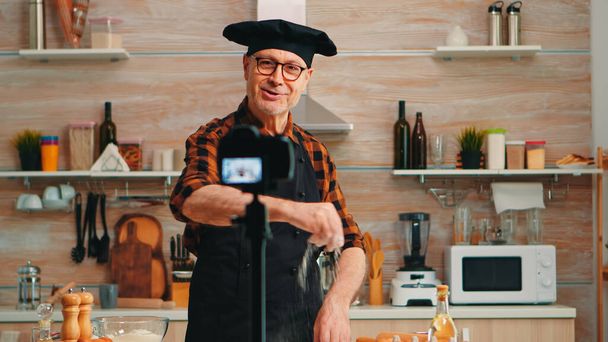 Porträt eines positiven Kochs, der Vlog in der Küche aufzeichnet - Foto, Bild