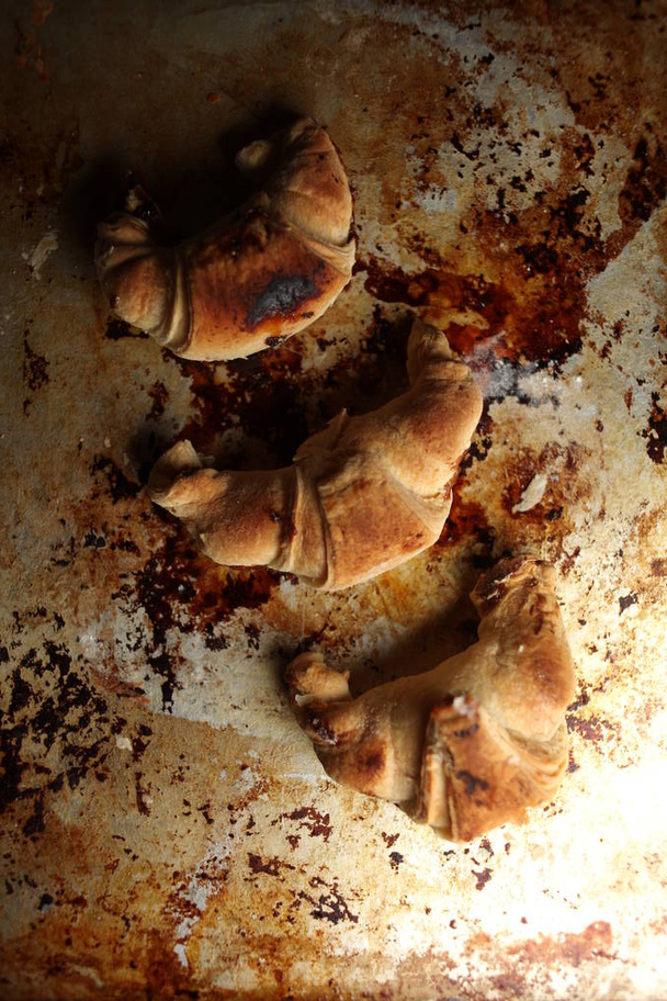 Sweet Chocolate Croissants, selective focus on old vintage background. Fresh homemade croissants with chocolate. Croissant with chocolate topping on the plate. - Photo, Image