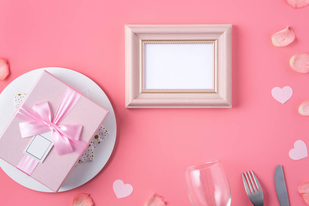 Valentine's Day design concept background with pink petals and gift box on pink background - Foto, afbeelding