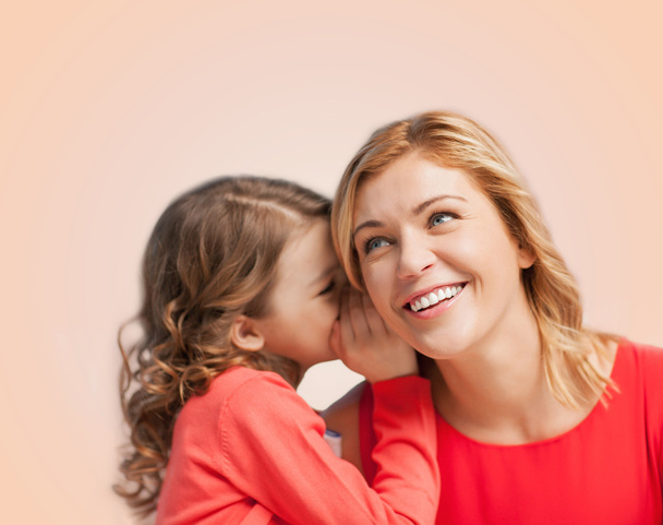 Smiling mother and daughter whispering gossip - Photo, image
