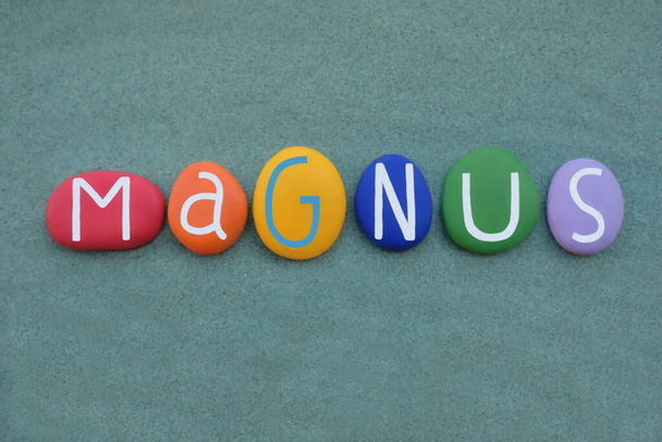 Magnus, İskandinav erkeksi ismi yeşil kumların üzerine çok renkli taş harflerle yazılmış. - Fotoğraf, Görsel