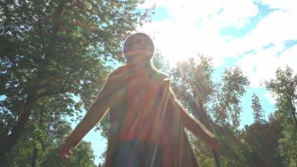 mulher feliz rodopiando no parque contra galhos de árvores e céu nublado - Filmagem, Vídeo