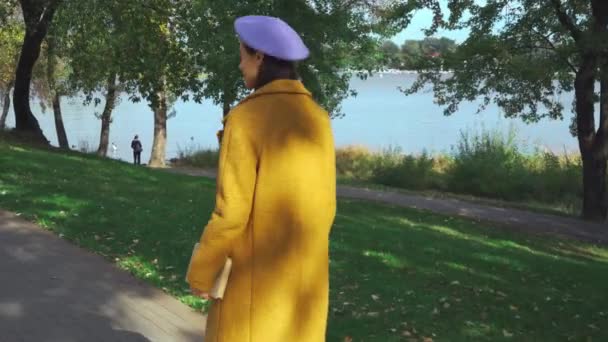 молода стильна жінка в осінньому одязі, що гуляє в парку з книгою
 - Кадри, відео