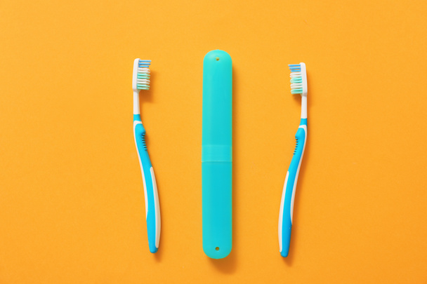 Зубные щетки и чехол на цветном фоне - Фото, изображение