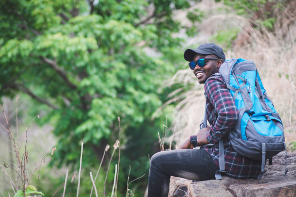 African man traveler sitting on the top of moutain with backpack - Foto, immagini