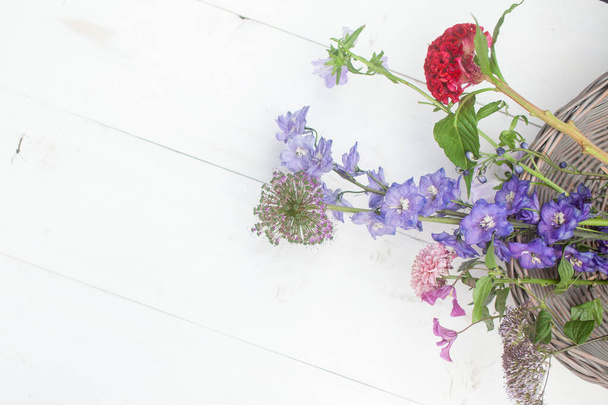 букет сухих цветов и ароматизаторов в деревянной тарелке на белом столе - Фото, изображение