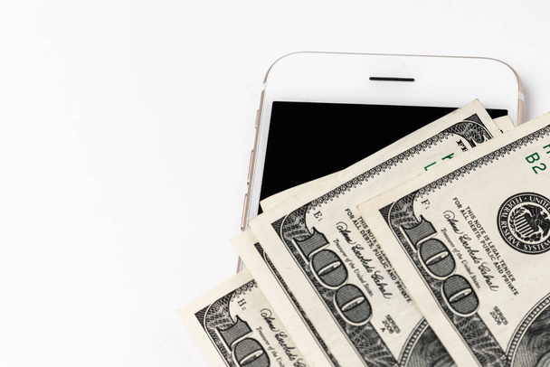 American dollars and smartphone isolated on white. Mobile payments concept - Photo, Image