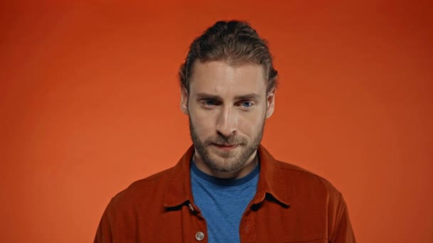 depresivní muž dotýkající se obličeje izolované na oranžové - Záběry, video