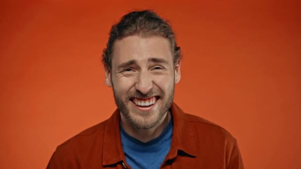 ενθουσιασμένοι άνθρωπος γέλιο σε κάμερα απομονωμένη σε πορτοκαλί - Πλάνα, βίντεο